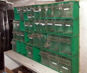 A traditional drawer unit with a green frame and transparent tilting drawers