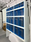 A van wall fitted with transparent tilting drawers of various sizes