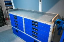 A workbench with a resin-coated marine plywood top and rear edge on a drawer unit