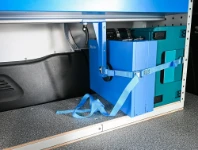 Cases secured with buckle straps on the van floor
