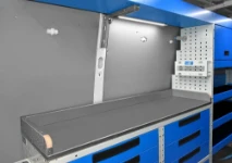 A workbench with a stainless-steel covering in a well-equipped van 